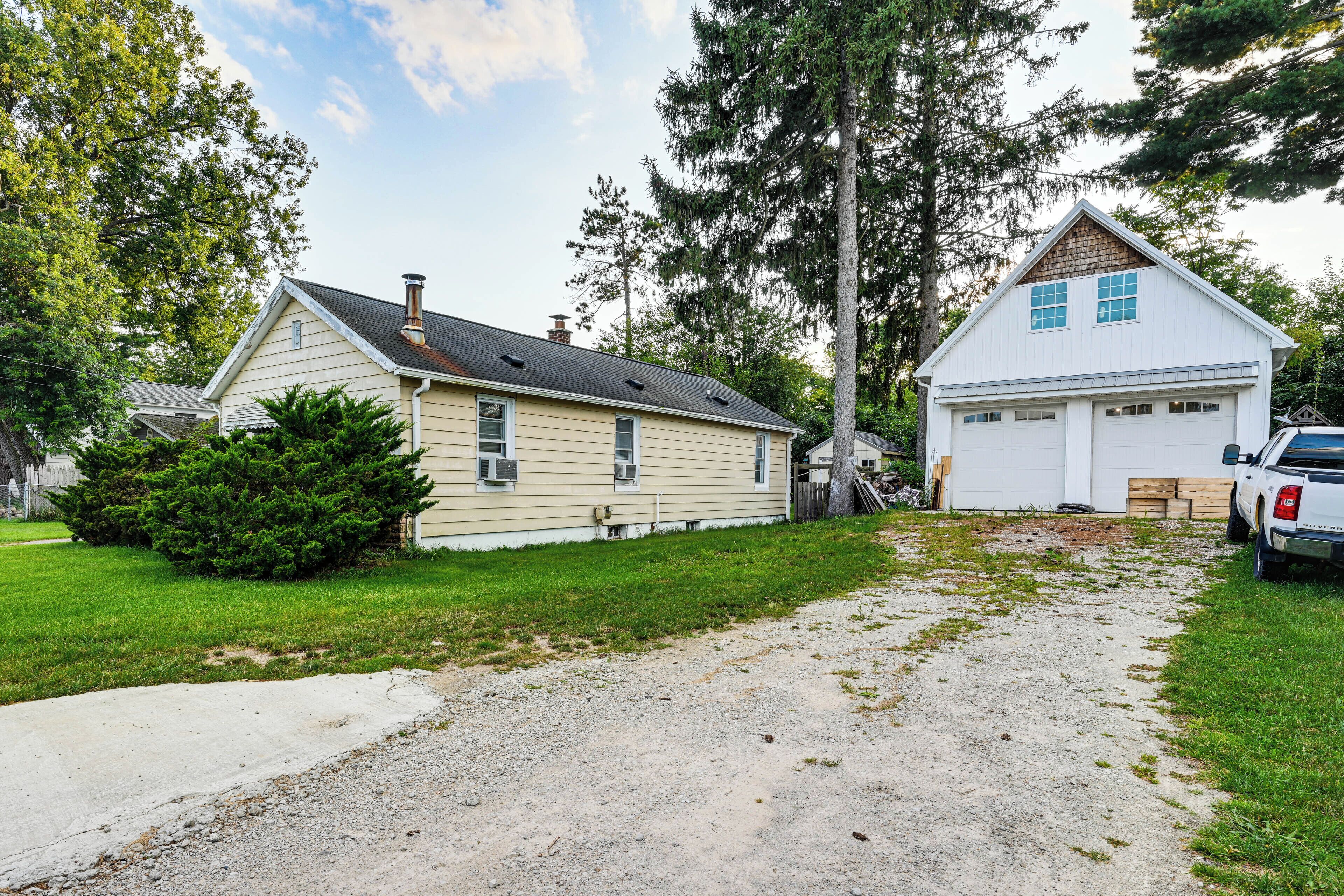 A two-story house with a garage, a driveway, and a truck parked in the driveway.