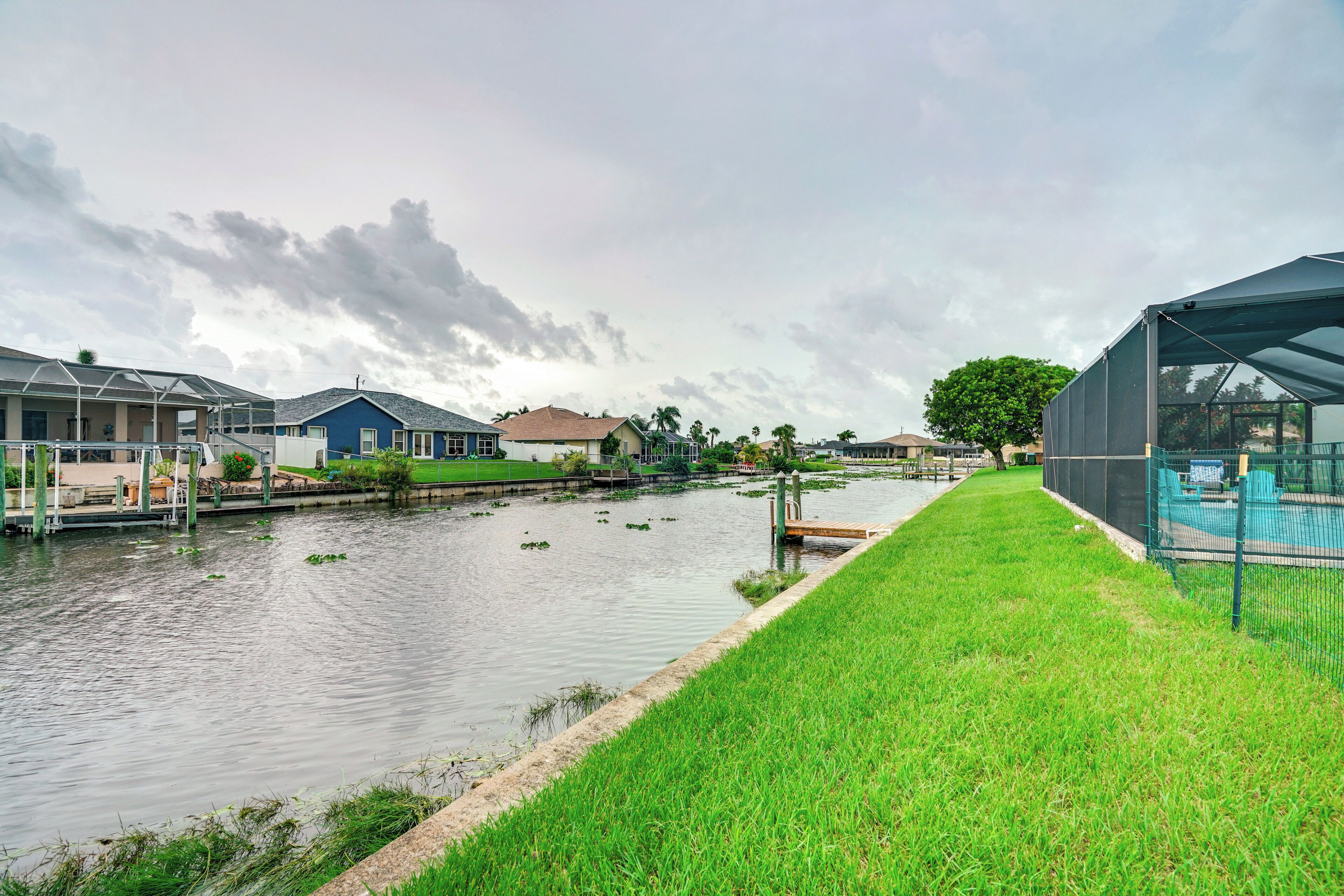 Zona residencial con casas, un sendero de césped y una masa de agua.