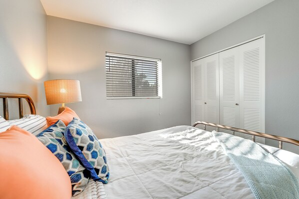 Une chambre à coucher avec un lit, une fenêtre avec des stores et une armoire.