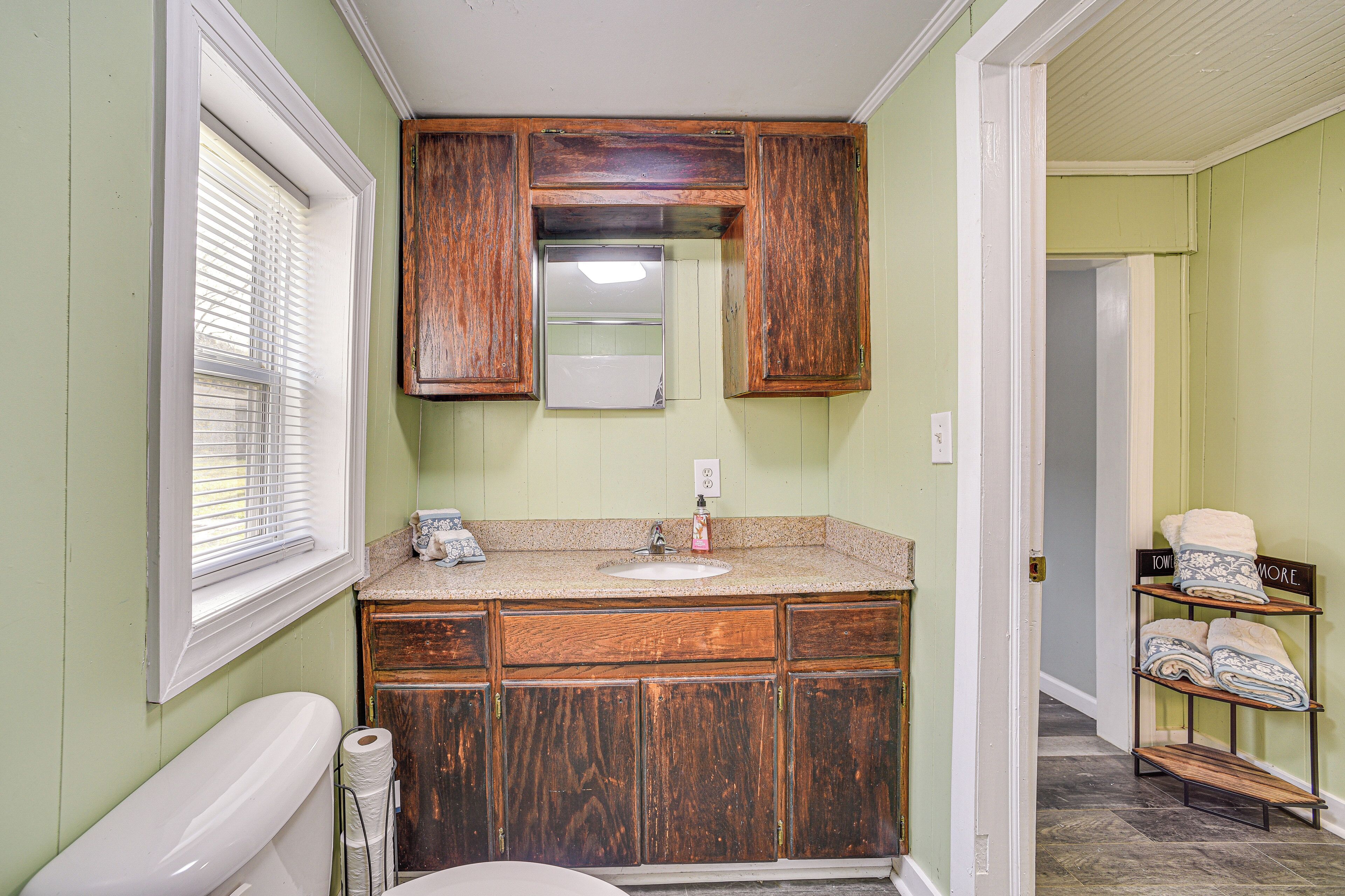 Un baño con armarios de madera, un lavabo y un inodoro.