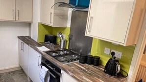 A compact kitchen with a gas stove, a toaster, and a kettle. - Melville Road Apartment - Birmingham City Centre (Birmingham)