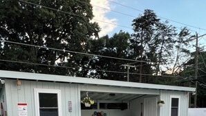 A small building with a pool, a covered patio area, and a bench.
