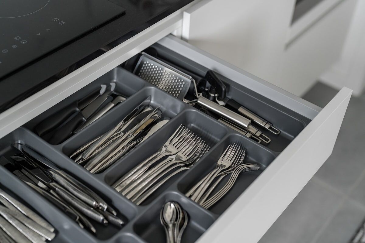 A drawer with utensils neatly organized in compartments.