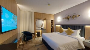 A modern hotel room with a large bed, a TV mounted on the wall, a desk, and a chair. - AW Hotel Riyadh (Riyadh)