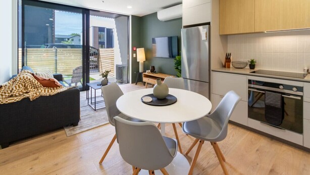 Una cocina moderna con comedor, sofá y vistas al exterior.