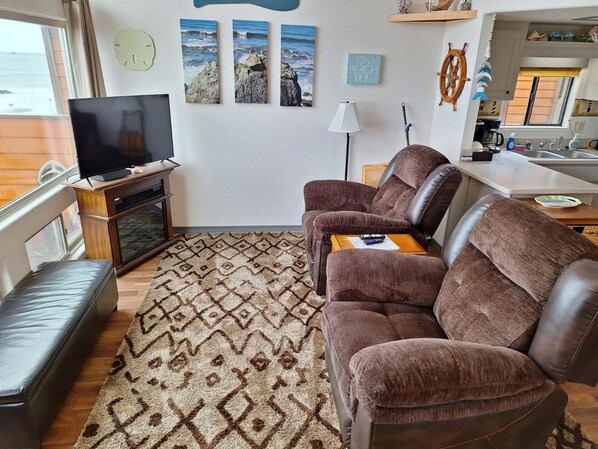 Un salon avec un canapé, un téléviseur et un tapis.