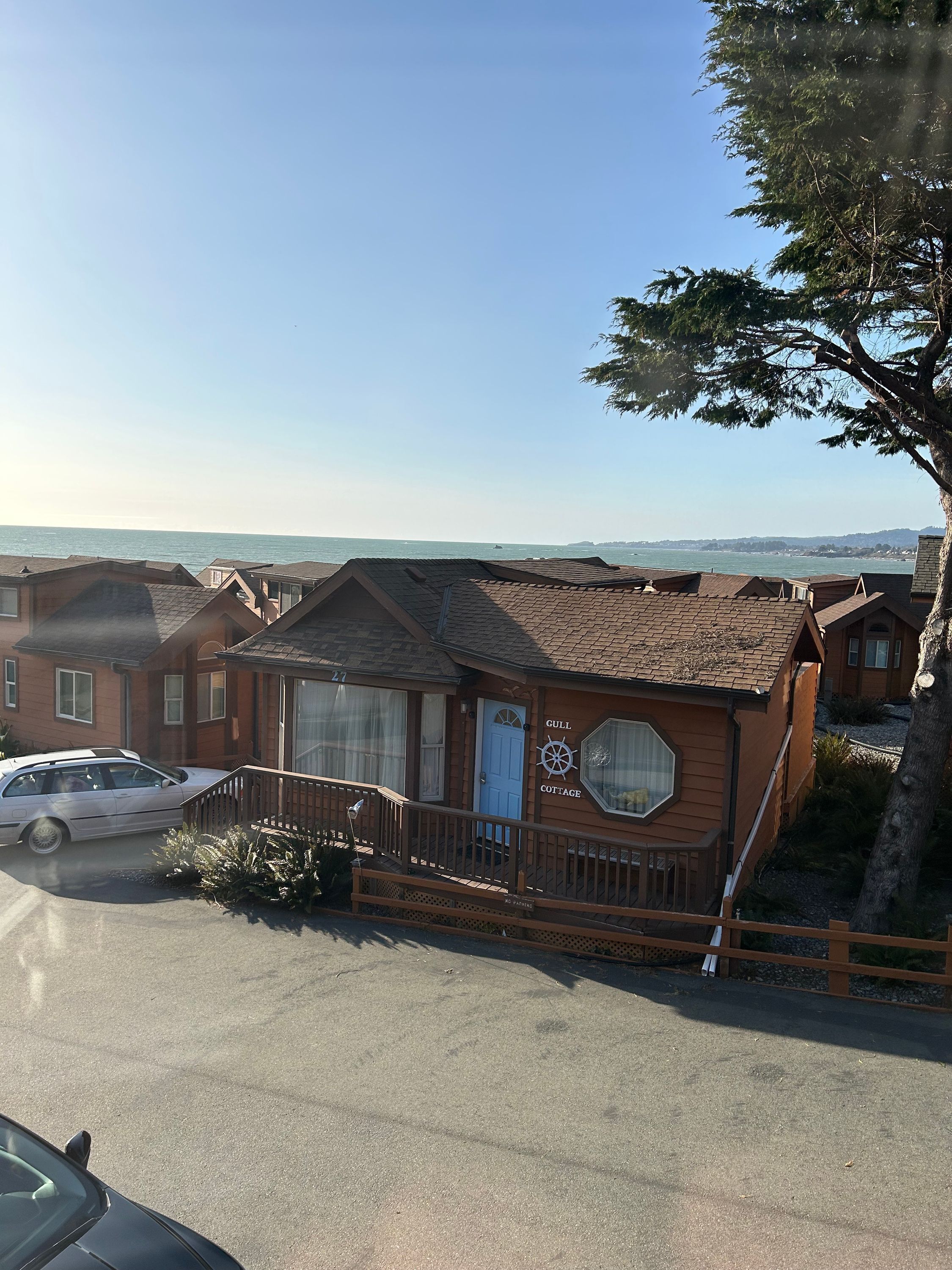 A coastal cottage with a deck and a view of the sea.
