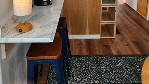 A modern kitchen with wooden cabinets, a marble countertop, and a built-in island. - Oceanview Cabin 27 w Jacuzzi Enjoyable Views (Smith River)