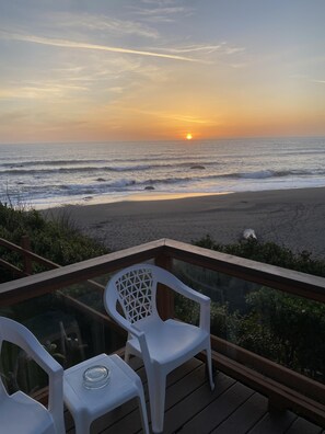 Enjoy a peaceful ocean view from this beachfront deck with a casual seating area.