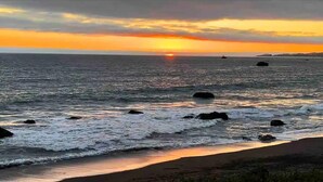 A beach with waves and a sunset. - Ocean Front Cabin 11 w Jacuzzi Superb Views (Smith River)