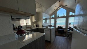 Una cucina moderna con isola centrale, ampie finestre e vista sul mare.