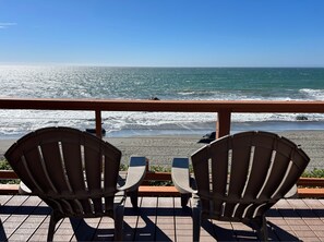 Two Adirondack chairs facing a beach with waves crashing onto the shore. - Oceanfront Cabin 10 Jacuzzi Breathtaking Views (Smith River)