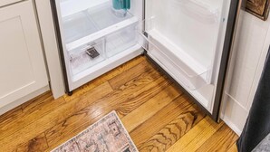A white refrigerator with two door compartments, a wooden countertop, and a patterned rug on the floor. - Evangeline A in Lafayette (Lafayette)