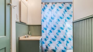 Un bagno con tenda doccia, lavandino e water.
