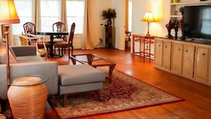 A living room with a sofa, chairs, a coffee table, a TV, and a cabinet. - Corporate Comfort Ideal Accommodation for Work Crews (Lafayette)