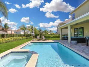 A swimming pool with a hot tub, surrounded by a well-maintained lawn and palm trees. - Luxurious Villa 9br Encore Resort Near to Disney (Kissimmee)