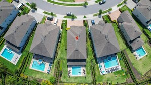 A residential area with multiple houses, each with a swimming pool and a well-maintained lawn. - Luxurious Villa 9br Encore Resort Near to Disney (Kissimmee)