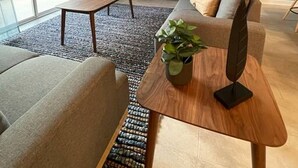 A modern living room with a ceiling fan, a flat-screen TV, a sofa, a coffee table, and a plant. - SL 4Br Walking Distance to Club (Kissimmee)