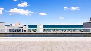 Uma piscina no terraço com vista para o oceano e a praia.