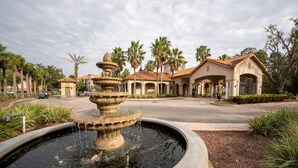 A fountain in a circular basin with a building in the background. - Tuscana Resort 3 BR Near Disney (Davenport)