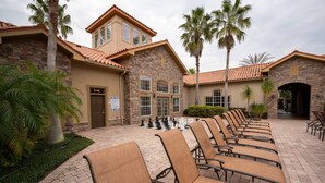 A building with a stone facade, a tiled roof, and a row of outdoor chairs. - Tuscana Resort 3 BR Near Disney (Davenport)