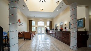 A spacious lobby with a reception desk, comfortable seating, and decorative pillars. - Tuscana Resort 3 BR Near Disney (Davenport)