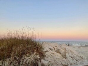 Na praia, espreguiçadeiras, toalhas de praia 