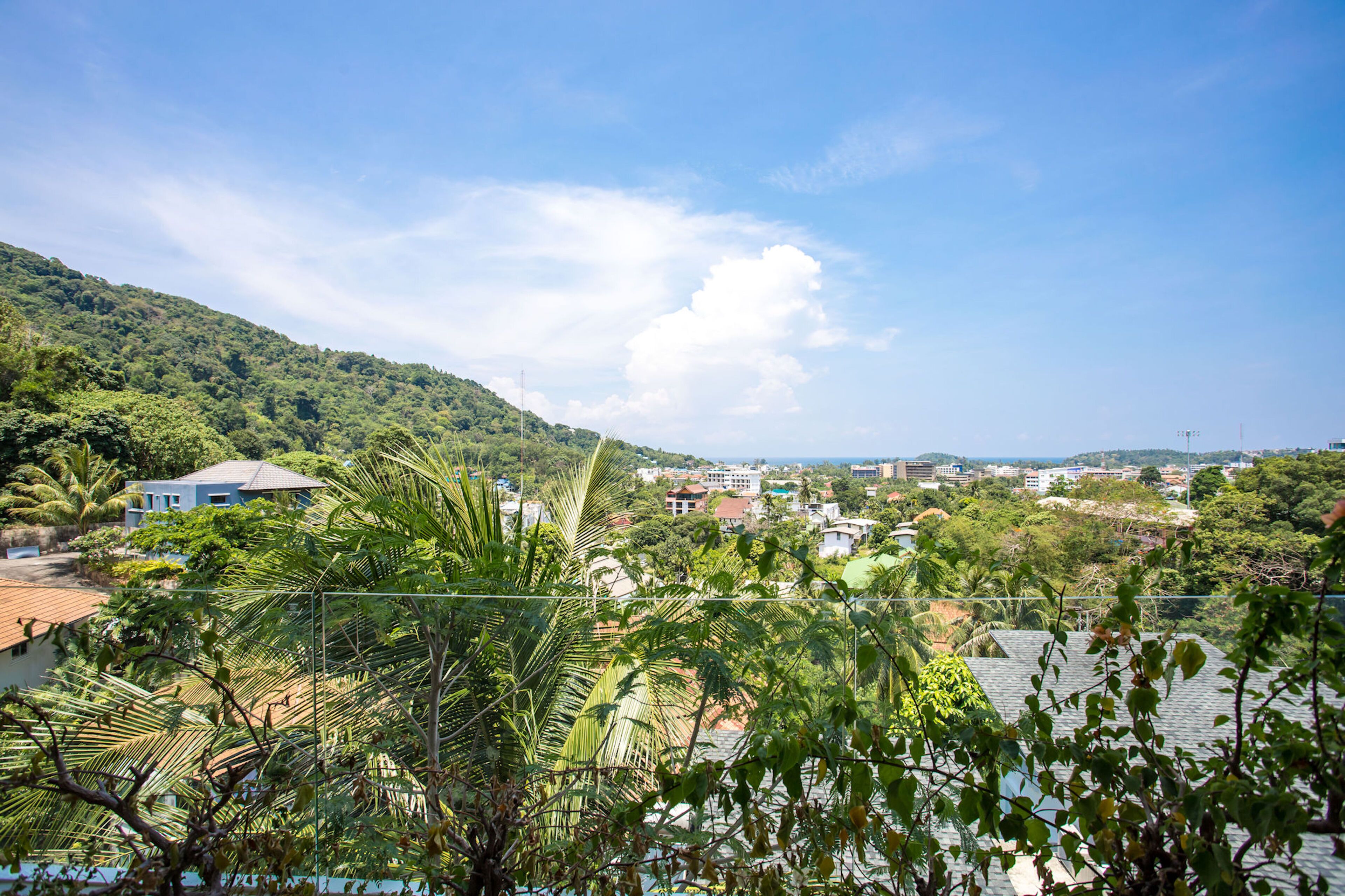 A residential area with houses, a hill, and a clear sky.