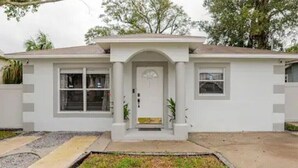 A single-story house with a front porch, a garage, and a small front yard. - Royal Rose Dream Getaway (Tampa)