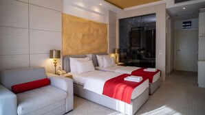 A modern hotel room with a large bed, a sofa, and a desk. - Hotel Atina by ENTOPYA (Budva)