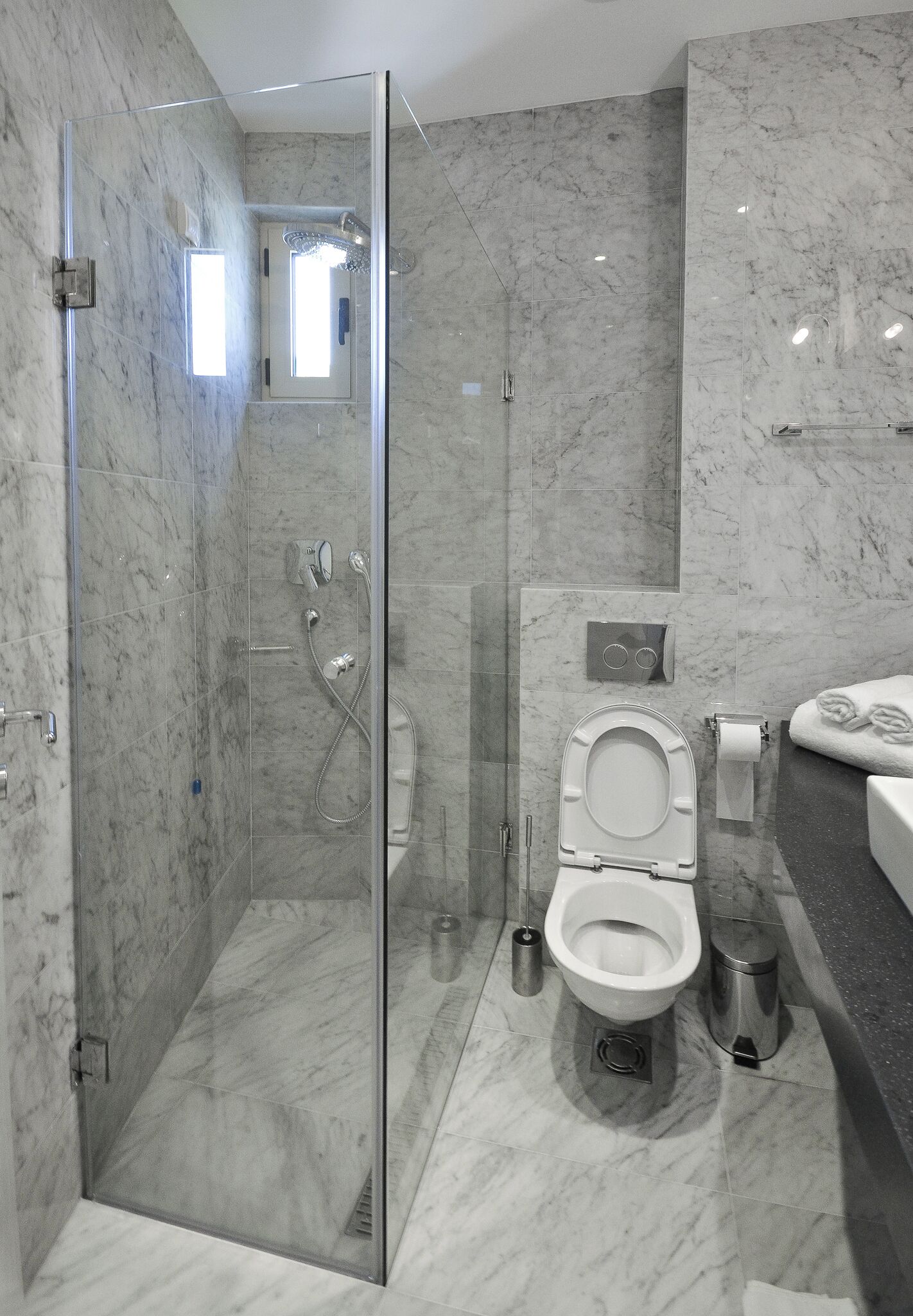 Une salle de bain moderne avec une douche à parois de verre, des toilettes et un lavabo.