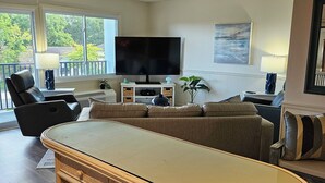 A living room with a large flat-screen TV, a sofa, a coffee table, and a dining table. - BEAUTIFUL IN TOWN! - 2 Bedroom 1 Bath on Rehoboth Ave.
Walk to Beach and Shops! (Rehoboth Beach)
