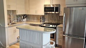 A modern kitchen with a central island, stainless steel appliances, and light wood cabinetry. - BEAUTIFUL IN TOWN! - 2 Bedroom 1 Bath on Rehoboth Ave.
Walk to Beach and Shops! (Rehoboth Beach)