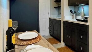 A modern kitchen with dark cabinets, a white countertop, and a woven placemat.