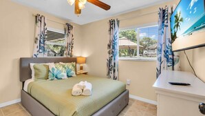 A bedroom with a bed, a nightstand, a lamp, a TV, and a window with curtains. - Waterfront, Boat Dock, Kayaks, Fishing, Pool, Spa. 4BR / 9Beds / Sleeps14 (Palmetto)