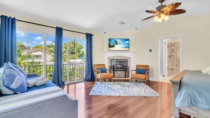 A spacious room with a large window, a fireplace, a ceiling fan, and a bed. - Waterfront, Boat Dock, Kayaks, Fishing, Pool, Spa. 4BR / 9Beds / Sleeps14 (Palmetto)