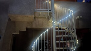 Un bâtiment moderne doté d’un escalier en colimaçon, d’un plafond en bois et de guirlandes lumineuses.