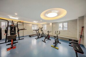 A gym with various exercise equipment, including treadmills and weight machines, and a bench. - Chuxiong Yuyu Holiday Hotel (Chuxiong City)