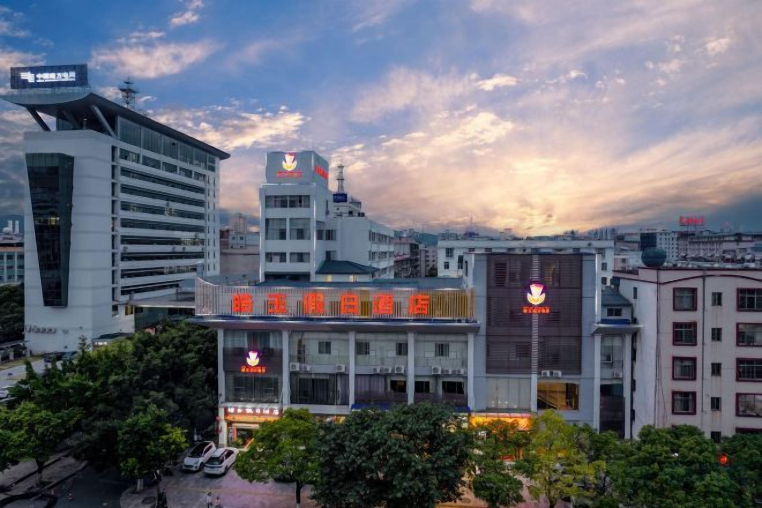 A hotel with a prominent sign and a modern building in the background.