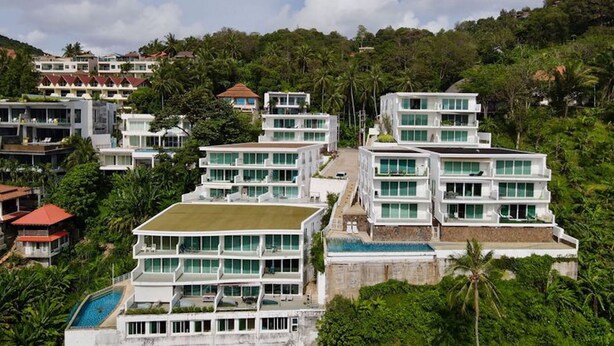 Ein modernes Resort mit mehrstöckigen Gebäuden, einem Schwimmbad und üppigem Grün, das das Anwesen umgibt.