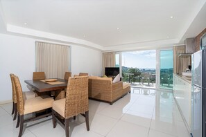 Departamento exclusivo, 2 habitaciones, balcón, vista parcial al océano | Área de sala de estar | Televisión de pantalla plana