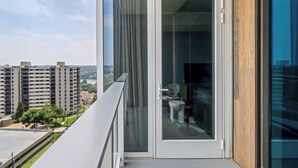 A modern apartment with a balcony overlooking a cityscape. - Modern Rainey St Oasis with Pool & Views (Austin)