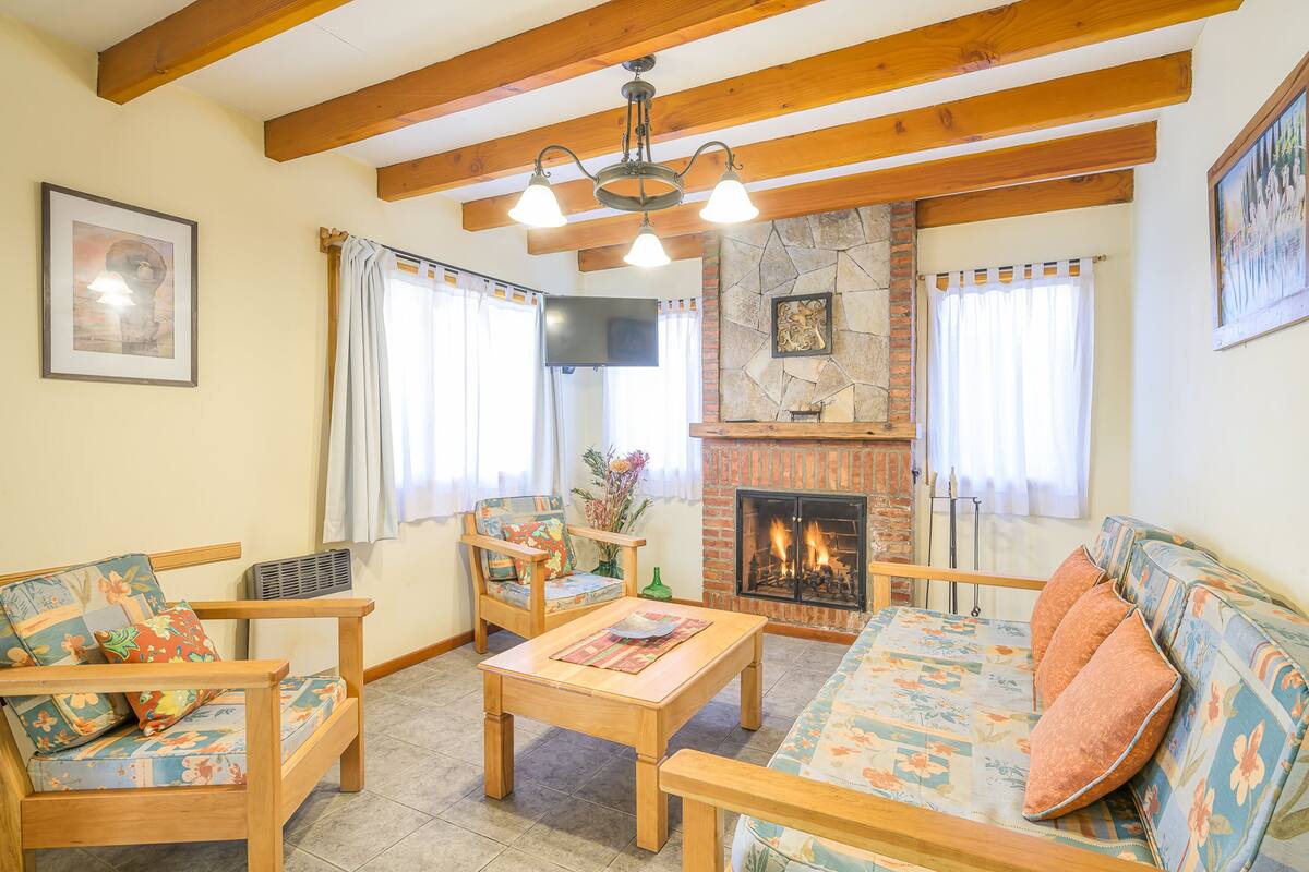 Ein Wohnzimmer mit Holzmöbeln, einem Kamin und einer Wand aus Stein.