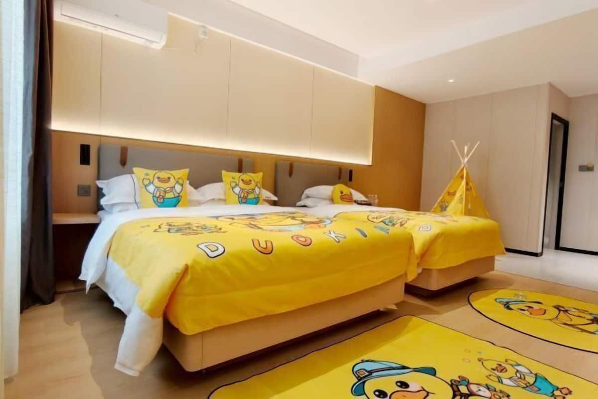 Een hotelkamer met twee bedden, een geel thema en een tipi-decoratie.