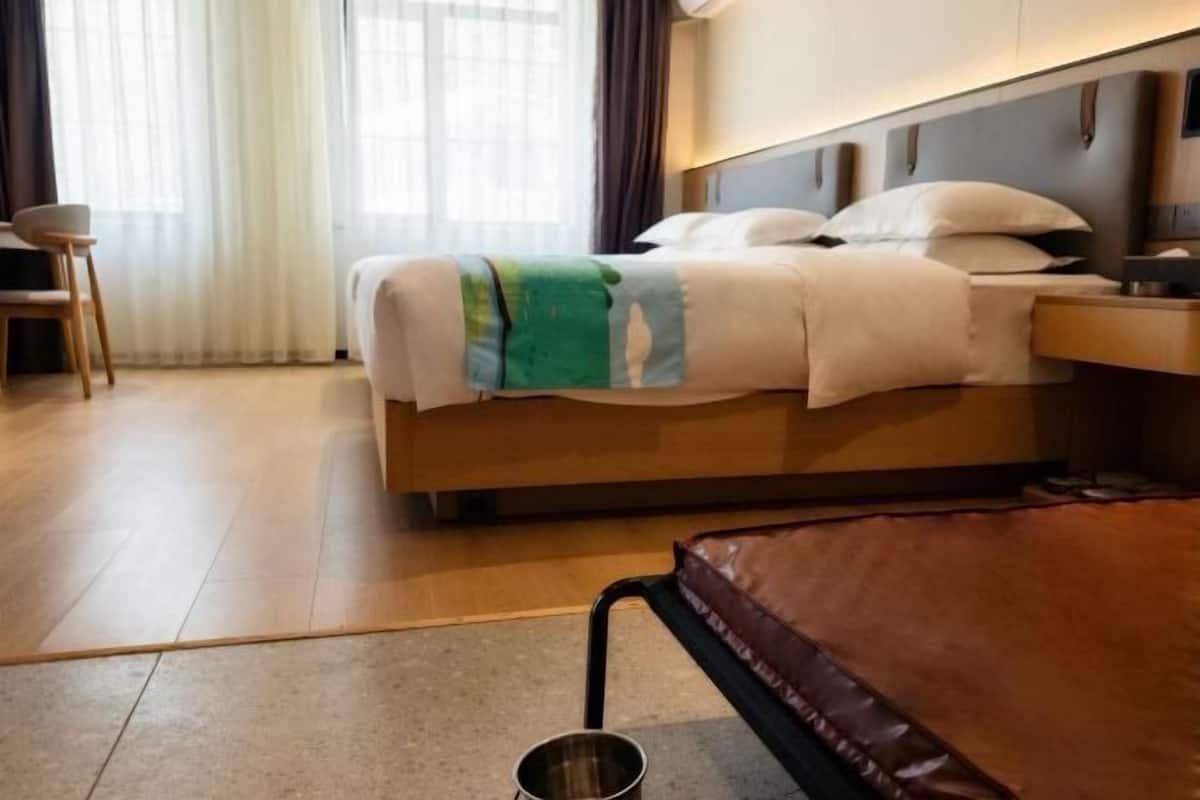 Een hotelkamer met een bed, nachtkastje en een stoel.