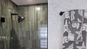 Une salle de bain moderne dotée d’une douche à parois de verre, de toilettes avec un mur en marbre et d’un porte-serviettes agrémenté de serviettes à motifs.