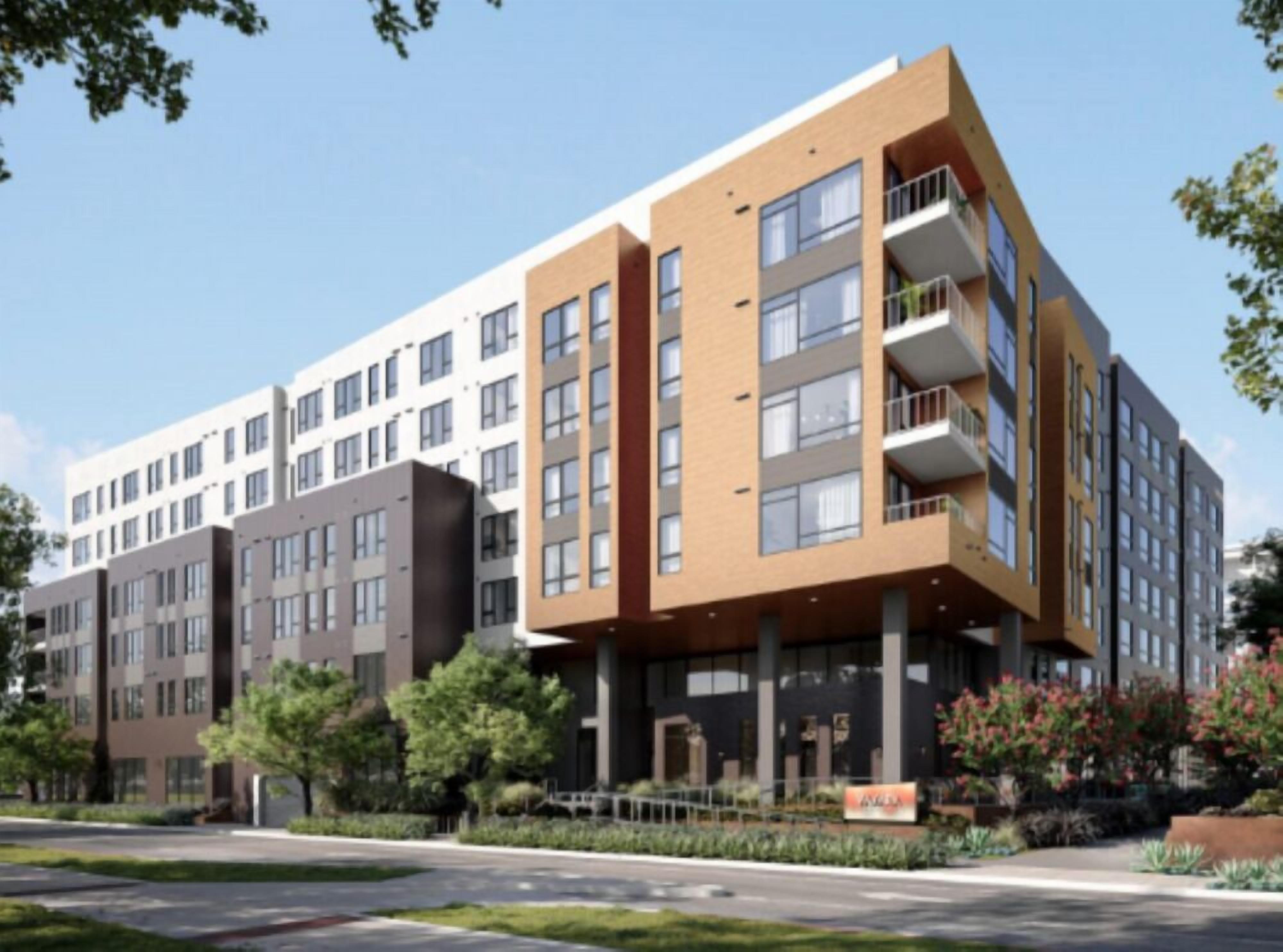 Un immeuble moderne à plusieurs étages, comprenant des logements et des espaces commerciaux, doté de balcons et de grandes fenêtres.