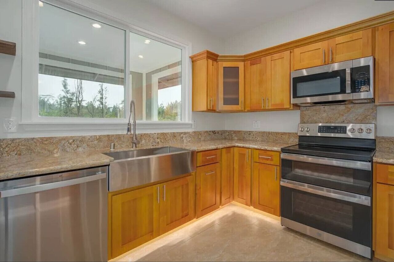 The full kitchen includes a stainless-steel farmhouse sink, dishwasher, microwave, and double oven.