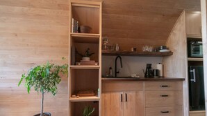 Una cuina moderna amb armaris de fusta, un forn integrat i una planta en test.