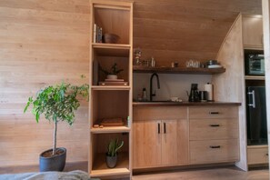 Una cocina moderna con armarios de madera, un lavamanos integrado y una planta en maceta.